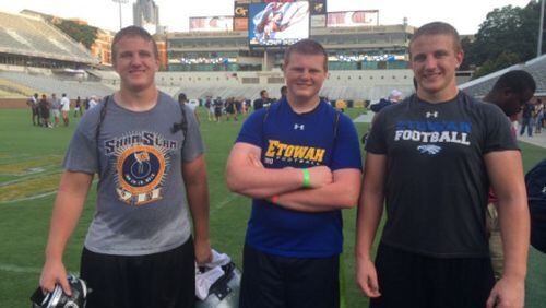 Signees Scott (left) and Brad (right) Morgan of Etowah High at a Georgia Tech camp, flanking their younger brother Matthew. (Special)