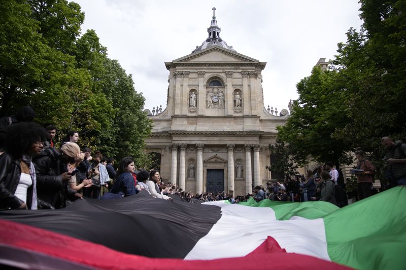Students demonstrate outside La Sorbonne university with a huge Palestinian flag, Monday, April 29, 2024 in Paris. About 100 Pro-Palestinian students demonstrate near the Sorbonne university in Paris. The demonstration came on the heels of protests last week at another Paris-region school, Sciences Po. (AP Photo/Christophe Ena)