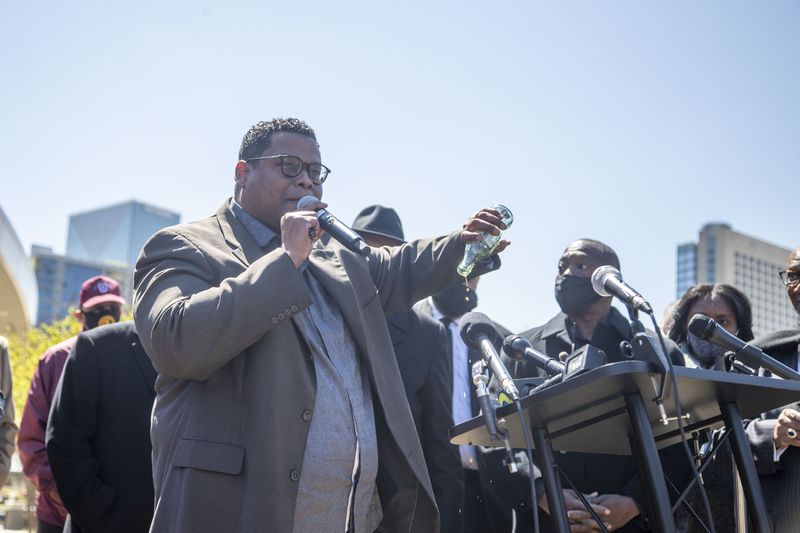 The Rev. Shanan E. Jones, president of the Concerned Black Clergy of Metropolitan Atlanta, pours out a bottle of Coca-Cola as he makes remarks during a press conference with other religious leaders outside of the World of Coca-Cola in downtown Atlanta, Thursday, April 1, 2021.  (Alyssa Pointer / Alyssa.Pointer@ajc.com)