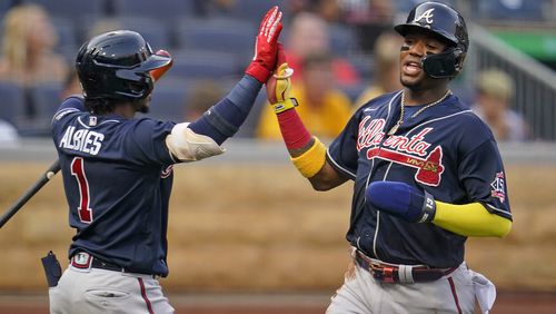 Atlanta Braves' Ronald Acuna Jr., right, is greeted by Ozzie Albies after scoring on a double by Freddie Freeman during the first inning of a baseball game in Pittsburgh, Monday, July 5, 2021. (AP Photo/Gene J. Puskar)