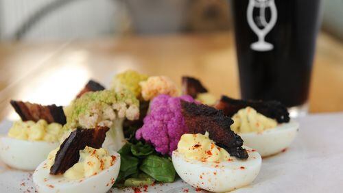 The Nest’s farm-fresh deviled eggs with house-cured bacon, served here with a SweetWater Pulled Porter. (Beckystein.com)