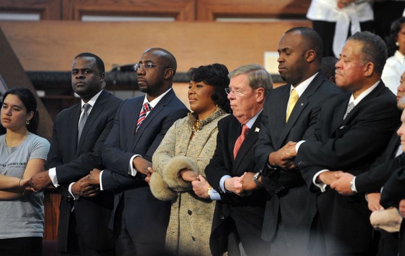 JANUARY 20, 2014 ATLANTA Podium guests including Sofia Campos (from left), Mayor Kasim Reed, Rev. Raphael Warnock, Dr. Bernice King, Senator Johnny Isakson, Bahamas Consul General Randy Rolle and Rev. Anthony Motley join members of the audience in singing "We Shall Overcome" at the conclusion of the 46th annual Martin Luther King Jr Commemorative Service at Ebenezer Baptist Church Monday, January 20, 2014. KENT D. JOHNSON/KDJOHNSON@AJC.COM