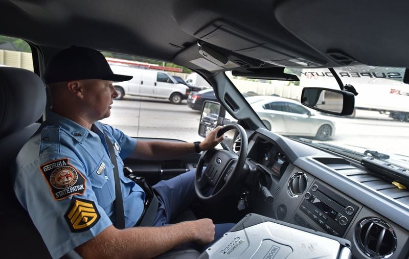 Sgt. First Class Chris Stallings monitors motorists in downtown Atlanta recently. On Sunday, police officers across the state will begin enforcing the Hands-Free Georgia Act, which prohibits motorists from holding their phones or other electronic devices while driving. HYOSUB SHIN / HSHIN@AJC.COM