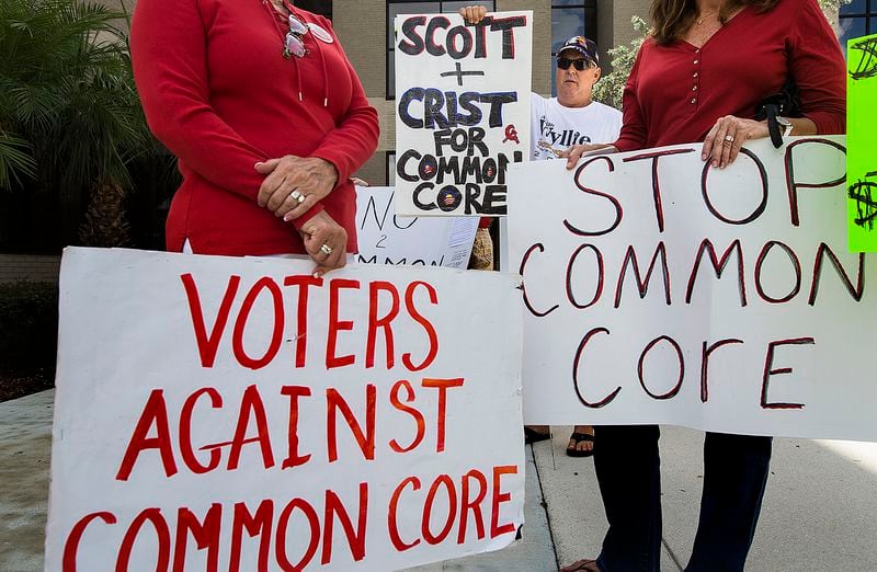 Dan Ray, holds up a sign with other opponents of Common Core outside the Palm Beach County School Board offices before a meeting in this 2014 file photo, in West Palm Beach. 