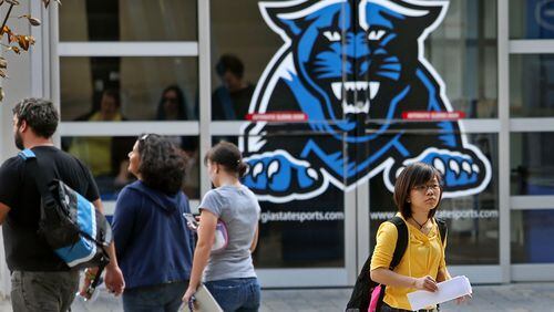 With a Georgia State University logo in the background, GSU students walk on campus along Decatur Street SE next to the GSU Sports Arena in this 2012 photo. JASON GETZ / JGETZ@AJC.COM
