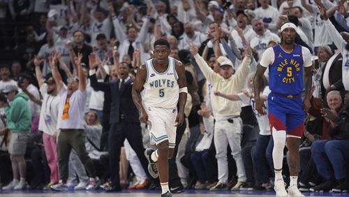 Minnesota Timberwolves guard Anthony Edward, left, runs down the court after making a 3-point shot against the Denver Nuggets during the first half of Game 6 of an NBA basketball second-round playoff series Thursday, May 16, 2024, in Minneapolis. (AP Photo/Abbie Parr)