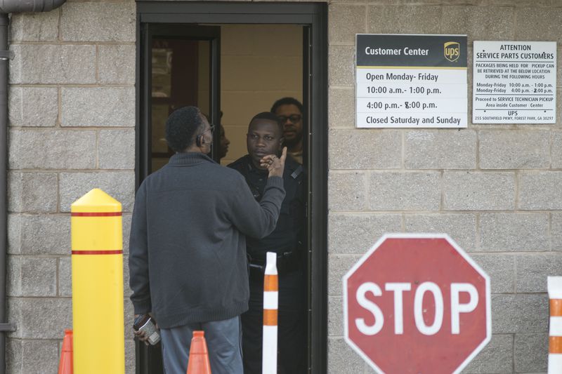 12/26/2017 -- Forest Park, GA, - A Clayton County police officer turns away a man at the entrance of the UPS customer center in Forest Park, Tuesday, December 26, 2017.  The officer informed customers that the customer center would not be accepting any more business around 2:50 Tuesday afternoon. The center stayed open a couple hours after its regular closing time to assist customers who had not received their orders before the Christmas holiday. ALYSSA POINTER/ALYSSA.POINTER@AJC.COM