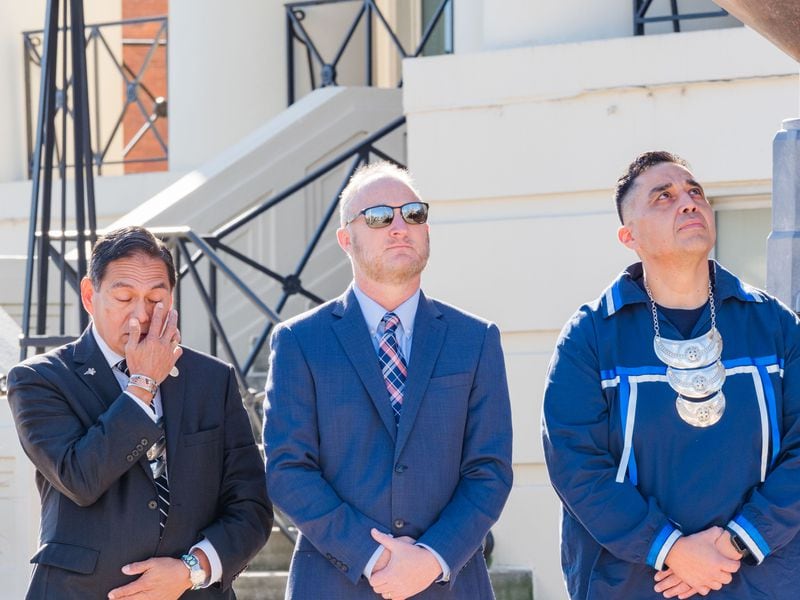 Chief David Hill (far left) of the Muscogee (Creek) Nation becomes emotional as the tribe's flag is raised over Macon City Hall. Macon Mayor Lester Miller (center) and 2nd Chief Del Beaver watch on.