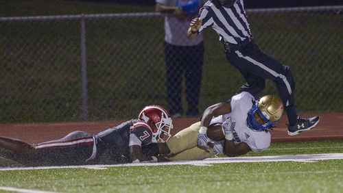 McEachern running back Mekhi Crawley (21) is brought down by HillgroveÕs Jawon Garner (7) just yards from the end zone in the second half of their game at Hillgrove High School Friday, September 25, 2020. PHOTO/Daniel Varnado 