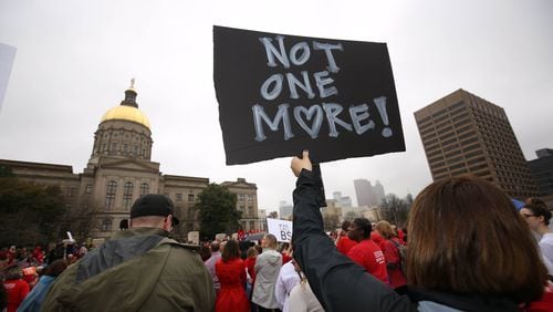 A protester holds a sign stating “Not one more” during the Moms Demand Action Advocacy Day rally Wednesday at Liberty Plaza, outside the Georgia Capitol. PHOTO / JASON GETZ