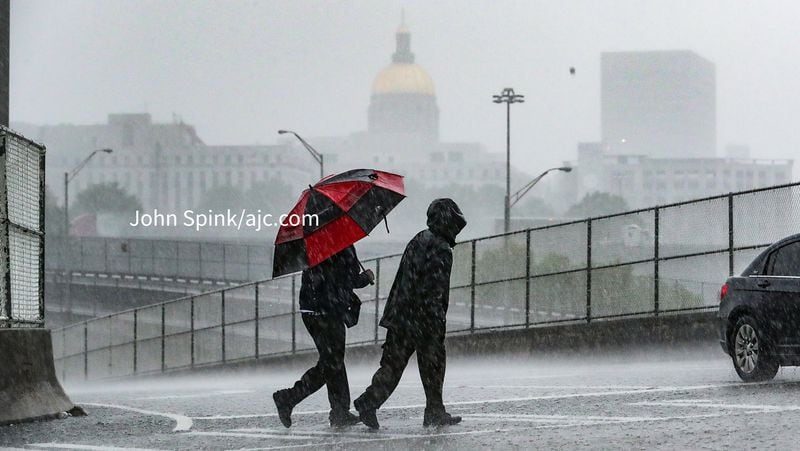 Two pedestrians walk during heavy rain in downtown Atlanta. A tornado warning was issued by the National Weather Service on Monday morning, May 3, 2021.