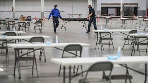 November 13, 2020 Stonecrest: DeKalb County’s John Matelski (left) and Kevin Buford (right) set up tables before a walkthrough by officials Friday, Nov. 13, 2020 of the vote counting facility at the former Sam’s Club in Stonecrest, where it plans to start its part of the recount at 7 a.m. Saturday. Officials said the facility which was used as an early voting site for the election provides more space and allows for better social distancing than would be possible at the county’s elections office off Memorial Drive. Joe Biden led Donald Trump by 14,000 votes as of Friday morning. The cost of Georgia recount six-day recount isn’t known, but initial estimates from DeKalb County indicate it might be pricey. DeKalb officials said Friday the recount will cost about $180,000, including $147,000 in pay, $20,000 for food and beverages, and $12,000 for personal protective equipment and other coronavirus-related precautions. The numbers are preliminary and may change, according to DeKalb. (John Spink / John.Spink@ajc.com) 