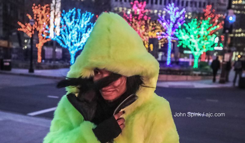 Whitney Teamer braves the cold at 15th and Peachtree streets. Temperatures dipped below freezing in Midtown Wednesday morning. JOHN SPINK / JSPINK@AJC.COM