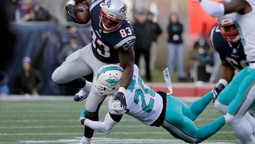 FILE - In this Nov. 26, 2017, file photo New England Patriots tight end Dwayne Allen (83) tries to make yardage as Miami Dolphins free safety Reshad Jones (20) tries to get a grip on him during the first half of an NFL football game, in Foxborough, Mass. With Rob Gronkowski out, New England will turn to Dwayne Allen for Monday's Dec. 11 game against the Dolphins.(AP Photo/Steven Senne, File)