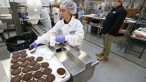 Owner Keith Schroeder (right) maintains social distance while walking the floor of his plant watching over production while Marianna Kunzmann works on ice cream sandwiches for Whole Foods at High Road Ice Cream on Tuesday, March 31, 2020, in Marietta. Curtis Compton ccompton@ajc.com