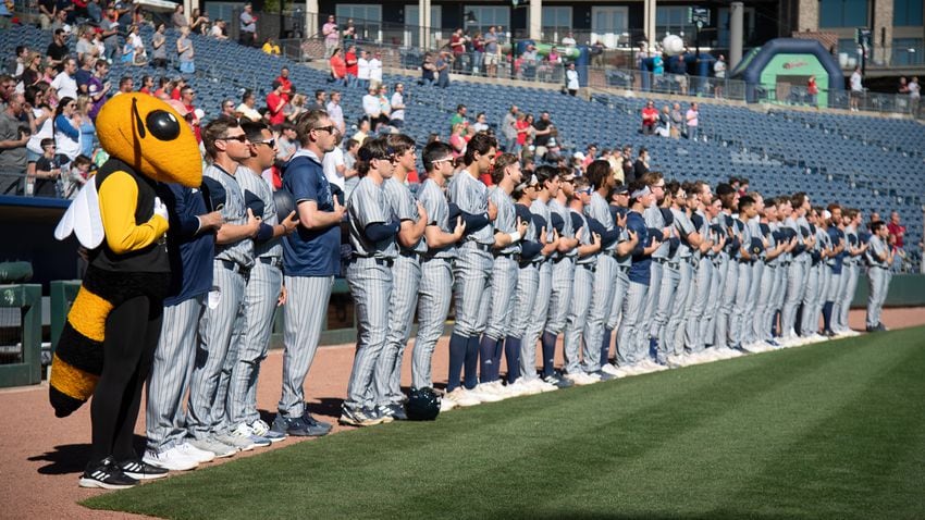 Buzz and the Georgia Tech baseball team stand during the national anthem before the 20th Spring Classic game Sunday at Coolray Field in Lawrenceville. (Jamie Spaar / for The Atlanta Journal-Constitution)