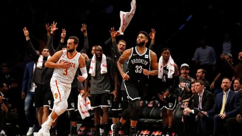 Brooklyn Nets' Allen Crabbe (33) reacts along with his bench after making a three-point basket in front of Atlanta Hawks' Marco Belinelli (3) during the fourth quarter of an NBA basketball game Sunday, Oct. 22, 2017, in New York. (AP Photo/Adam Hunger)