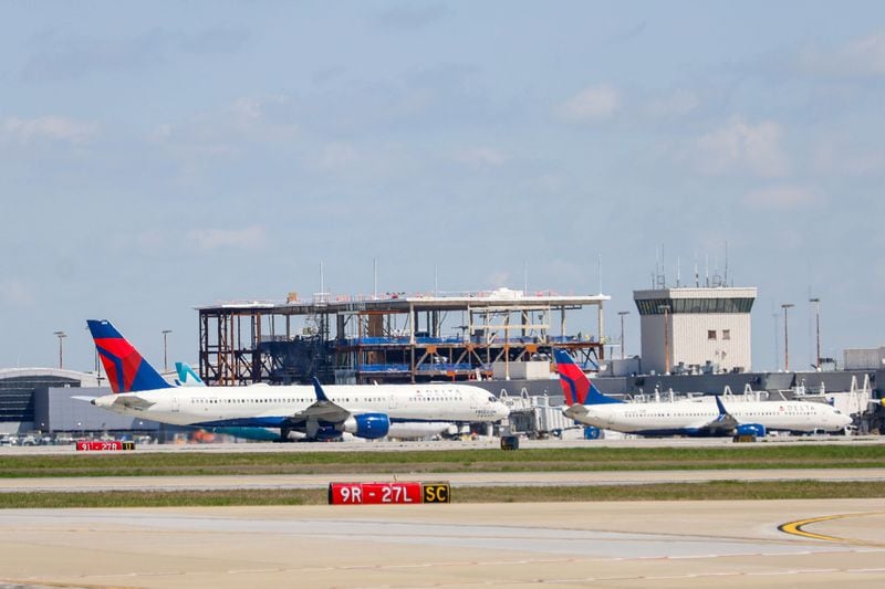 A couple of Delta airplanes pass on a taxiway as the new Delta sky lounge is seen under construction by Concourse D at Hartsfield-Jackson Atlanta International Airport on Wednesday, March 27, 2024.
 Miguel Martinez /miguel.martinezjimenez@ajc.com