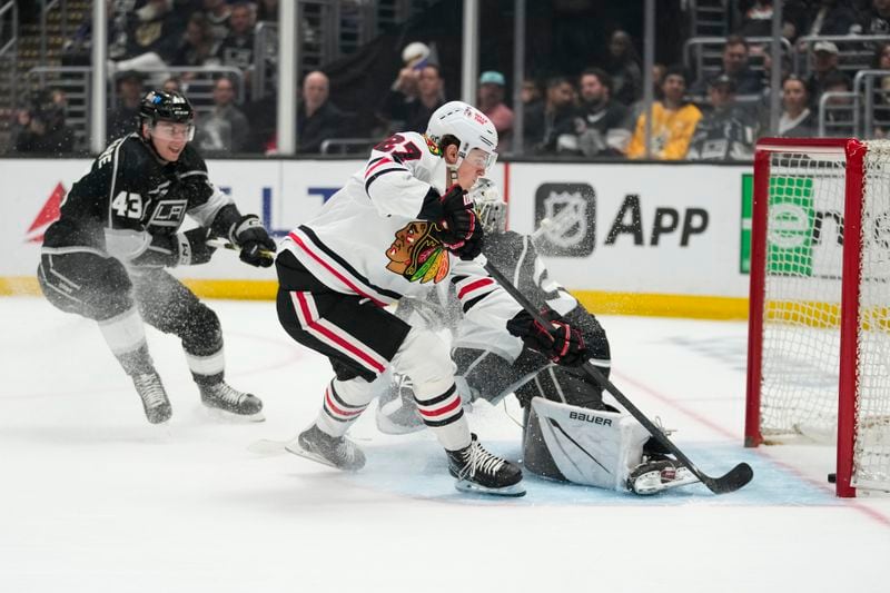 Chicago Blackhawks left wing Lukas Reichel (27) scores against Los Angeles Kings defenseman Jacob Moverare (43) and goaltender Cam Talbot (39) during the first period of an NHL hockey game Thursday, April 18, 2024, in Los Angeles. (AP Photo/Ashley Landis)