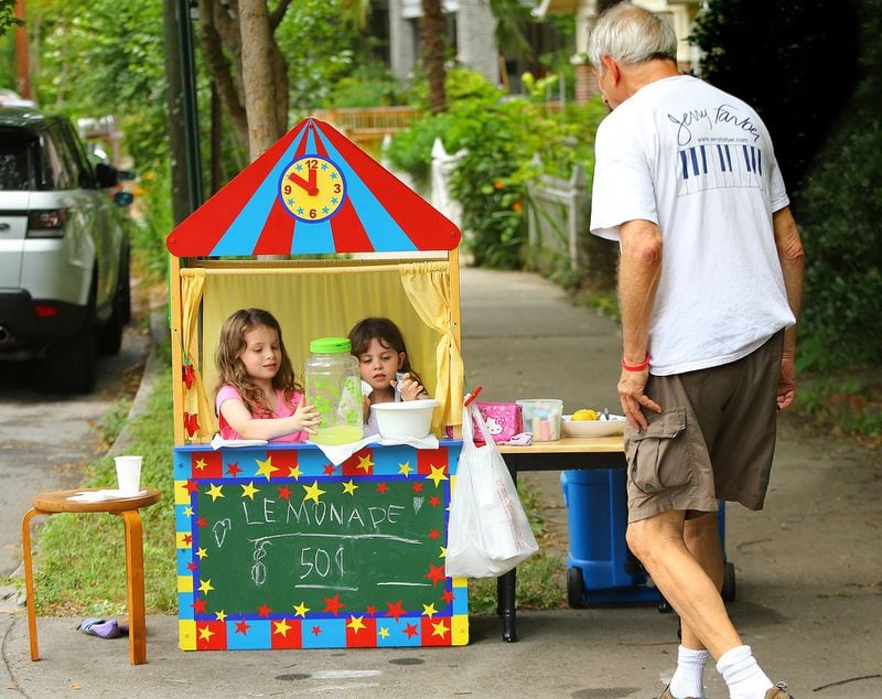 In this 2014 file photo, Jerry Farber stops to buy a cup of lemonade from Cayla Drake (left), 7, and her sister Jamie Drake (right), 5, who set up shop converting their puppet house into a lemonade stand for 50 cents a cup in the yard of their home just a block away from the Virginia-Highland Summerfest. Such an endeavor can help kids work on their math skills in summer. CURTIS COMPTON / CCOMPTON@AJC.COM