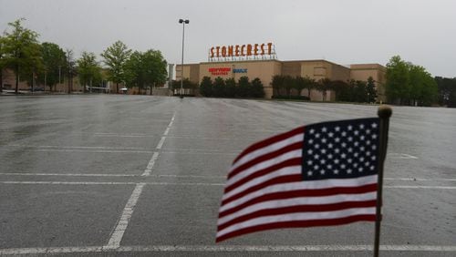 A small American flag waves at the edge of an the empty parking lot outside The Mall at Stonecrest in Marcht.    Curtis Compton/ccompton@ajc.com