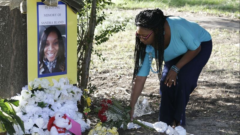 Jeanette Williams places a bouquet of roses at a memorial for Sandra Bland near Prairie View A&M University, Tuesday, July 21, 2015, in Prairie View, Texas. Bland, 28, died of apparent suicide in her jail cell three days after a July 10, 2015, traffic stop near the campus, where she attended college and had just gotten a new job. Former Texas state Trooper Brian Encinia, then 30, was fired and indicted for perjury in the case, but his perjury charge was later dropped in exchange for his never seeking another law enforcement job. Bland’s face became a prominent one in the Black Lives Matter movement following her death in police custody.