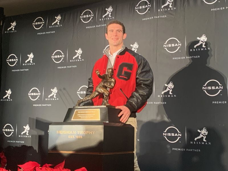 Georgia quarterback Stetson Bennett poses with the Heisman Trophy in New York on Friday. Bennett is one of the four finalists for the prestigious award. The winner will be announced Saturday.