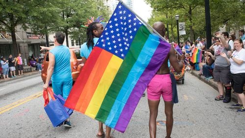 People head down Peachtree Street with flags during the Atlanta Pride Parade in this file photo from 2017. Steve Schaefer / Special to the AJC