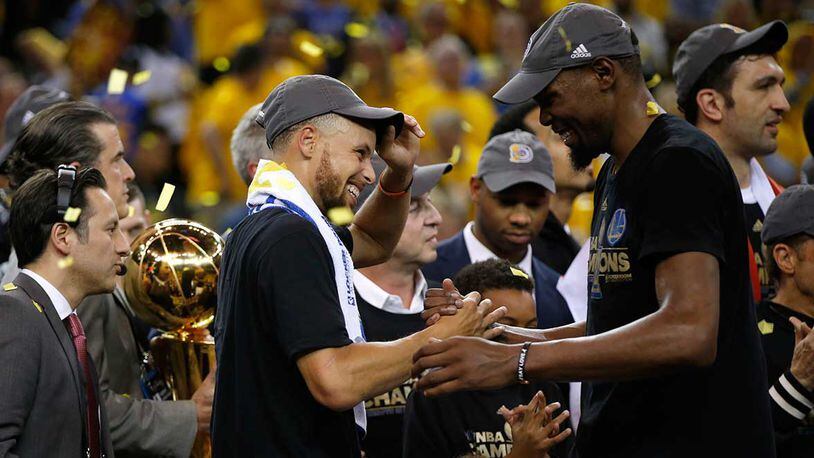 Stephen Curry and Kevin Durant celebrate after Golden State won the NBA championship in June.