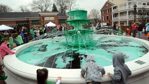 Festival goers gather at Smyrna's Market Village fountain to watch an annual "dying of the fountain, " which turns the fountain waters green.