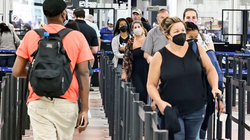 Masked and unmasked passengers walk through security checkpoint at Hartsfield-Jackson International Airport on Tuesday, July 19, 2022.  (Natrice Miller/natrice.miller@ajc.com)
