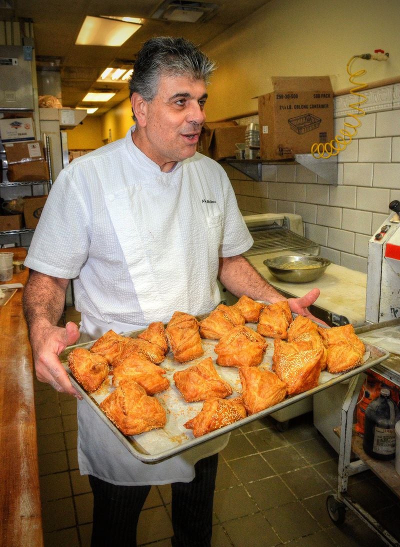Chef Alon Balshan holds a just-baked tray of cheese-stuffed borekas. He insists they be eaten hot or warmed up in the oven. PHOTO CONTRIBUTED BY CHRIS HUNT; FOOD STYLING BY ALON BALSHAN