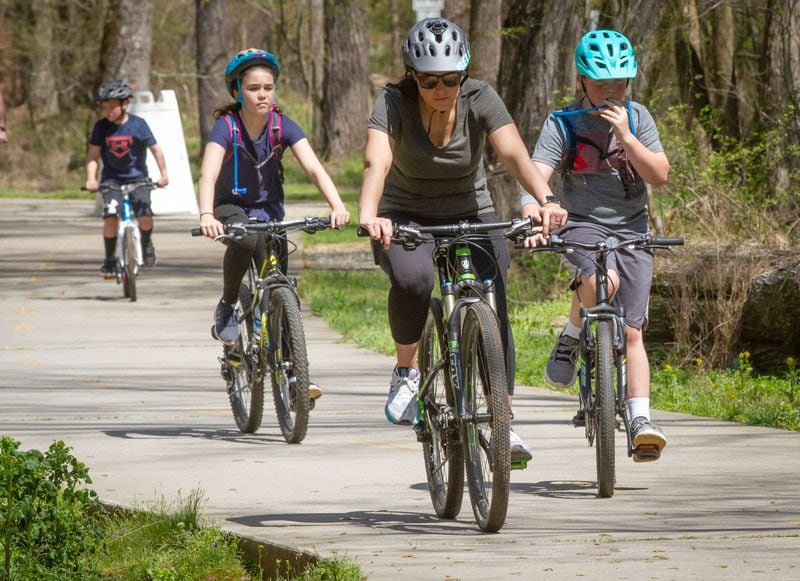 A family takes advantage of the summer-like weather for a bike ride on the Big Creek Greenway trail near Alpharetta Friday, March 27, 2020.   STEVE SCHAEFER / SPECIAL TO THE AJC