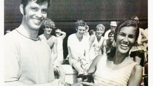 Tim Singleton hands over the hardware and congratulates Gayle Barron, the first women’s winner of the AJC Peachtree Road Race in 1970.