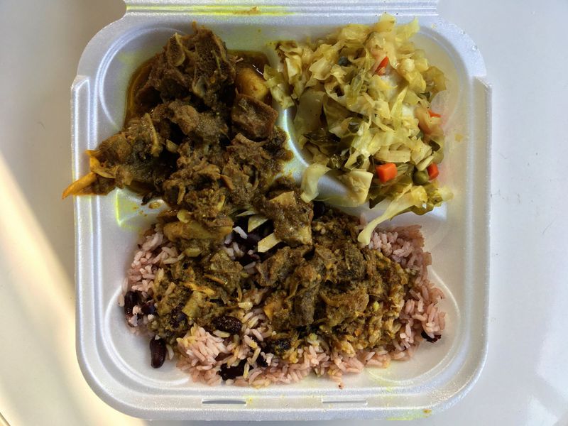 The heaping serving of curry goat and gravy adds richness to the rice and peas at Irie Mon Cafe in Buckhead. PHOTO CREDIT: Wyatt Williams