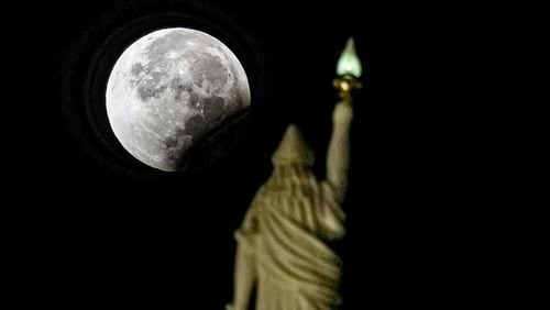 Miss Freedom at the Georgia State Capitol checks out the lunar eclipse. John Spink / jspink@ajc.com