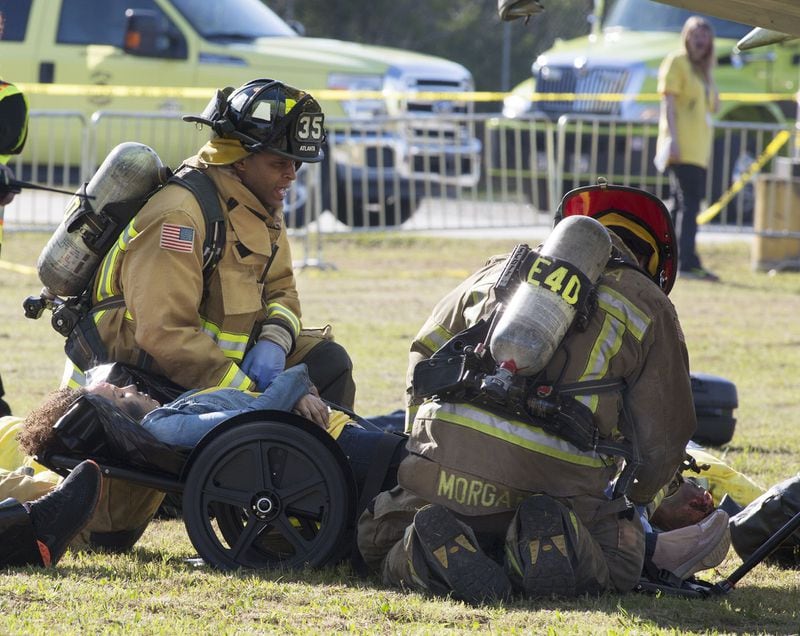 Firefighters prepared to move a victim as Hartsfield-Jackson International Airport held a full-scale disaster drill with Atlanta Firefighters, law enforcement, rescue personnel and nearly 150 volunteers who participated in a triennial exercise known as âBig Birdâ on Thursday, April 12, 2018. Airport personnel mobilized to a mock aircraft crash, extinguished the fire then triaged & treated the victims at a training site. The Federal Aviation Administration requires airports to conduct annual emergency preparedness drills and at least one full-scale drill every three years. (Photo by Phil Skinner)NOTE: getting Ids was impossible because the media was too far away.