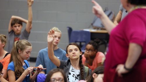 Ellie Kessler raises her hand at a session at Lanier Middle School in Sugar Hill beginning an annual project for a select number of eight graders under the school’s TWIST program. TWIST stands for Teamwork With Innovative Skills & Technology. The school is kicking off a program to involve more girls in science, technology, engineering and math courses. Georgia, like the rest of the nation, is struggling with an academic gender gap in science and math. BOB ANDRES /BANDRES@AJC.COM
