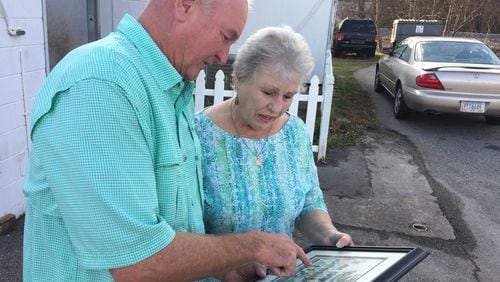 David Davidson, an old friend of Sonny Perdue, and Tina Evans, manager at the White Diamond Grill in Bonaire, look at a photo of Sonny Perdue and Davidson as kids in Little League baseball. They are outside the grill. They both support Perdue, who was recently tapped to be the U.S. Secretary of Agriculture.