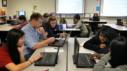 Collyn Milsted (center) helps a student during her AP Language Arts class at The Gwinnett School of Math, Science & Technology.