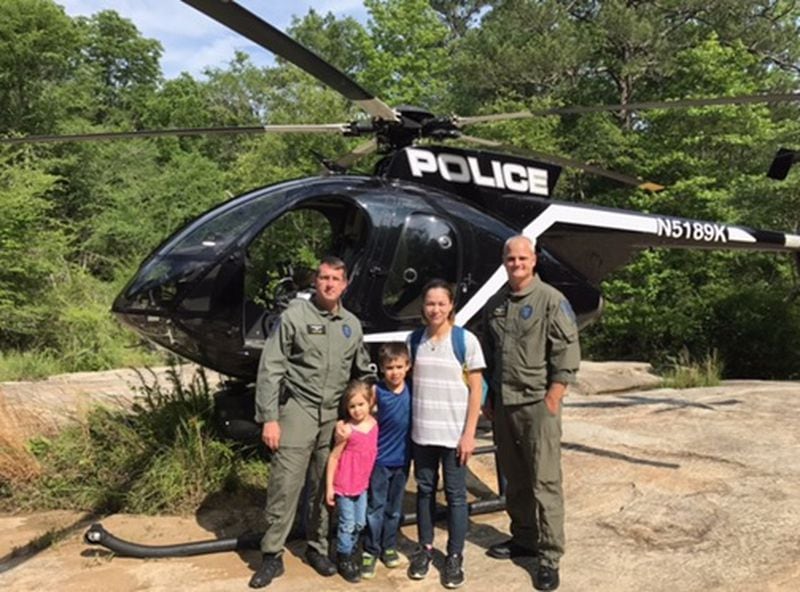 After a Gwinnett County Police Department helicopter crew rescued them, a family posed for a photo with the team/Gwinnett County Police Department
