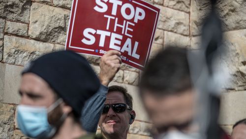 A man holds a sign during a "Stop the Steal" rally outside the Georgia Capitol building in downtown Atlanta on January 6, 2021. (Alyssa Pointer / Alyssa.Pointer@ajc.com)
