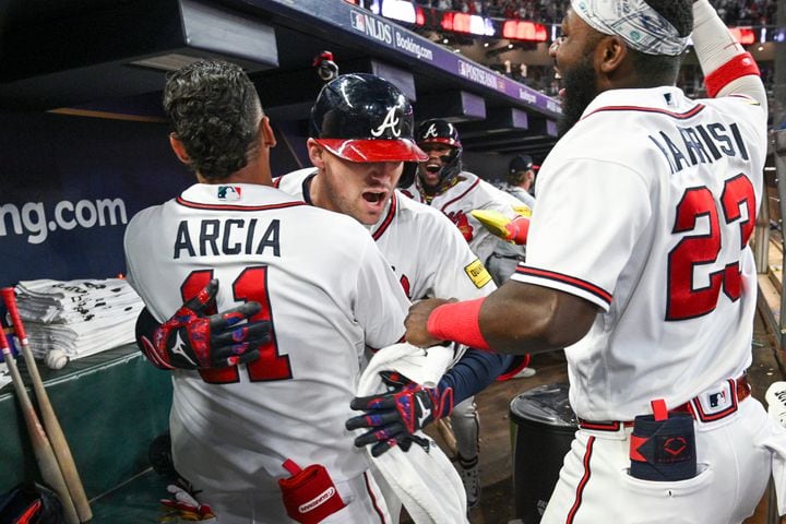 Atlanta Braves’ Orlando Arcia (11) and Michael Harris II (23) celebrate with Austin Riley after his two-run home run against the Philadelphia Phillies during the eighth inning of NLDS Game 2 in Atlanta on Monday, Oct. 9, 2023.   (Hyosub Shin / Hyosub.Shin@ajc.com)