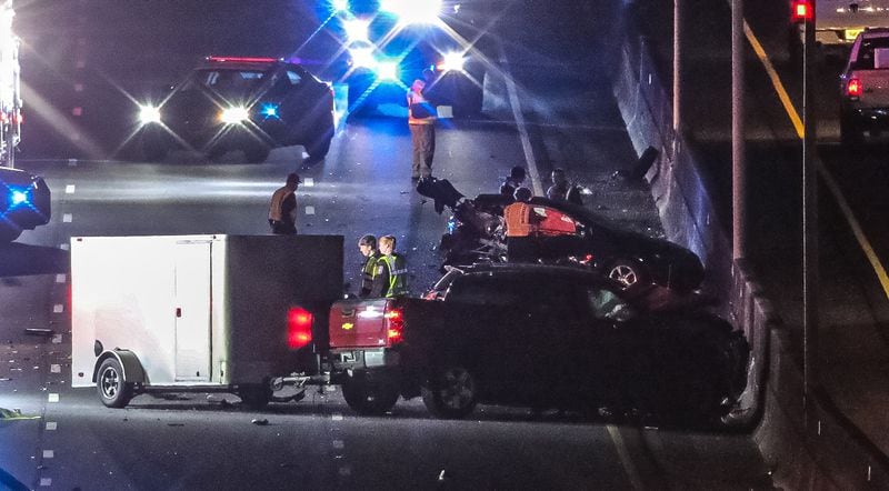 A red pickup truck hauling a small trailer and a crumpled sedan were among the vehicles involved in a deadly wreck Tuesday on I-75 in Marietta. 