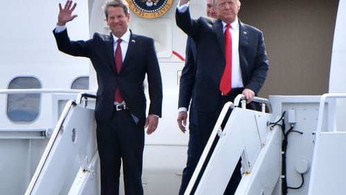 GOP gubernatorial candidate Brian Kemp and President Donald Trump wave from Air Force One as President Donald J. Trump arrives during President Donald J. Trump's Make America Great Again Rally to support Brian Kemp at Middle Georgia Regional Airport in MaconSunday, November 4, 2018. HYOSUB SHIN / HSHIN@AJC.COM