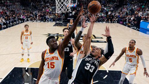 San Antonio Spurs guard Tre Jones (33) drives to the basket against Atlanta Hawks center Clint Capela (15) during the second half of an NBA basketball game in San Antonio, Sunday, March 19, 2023. (AP Photo/Eric Gay)