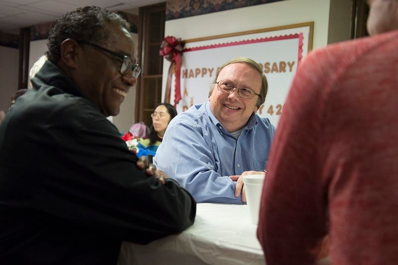 Darrell Pursiful, of First Baptist Church of Christ on High Place, talks to Alveno Ross, a deacon at First Baptist Church on New Street, after eating Thanksgiving Potluck at First Baptist Church on Sunday, Nov. 19. (Jenna Eason / for the AJC)
