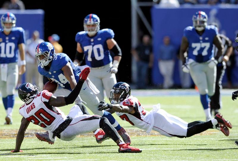 New York Giants running back Shane Vereen, center, runs with the ball as Atlanta Falcons defensive back Phillip Adams, left, and free safety Ricardo Allen defend during the second half of an NFL football game, Sunday, Sept. 20, 2015, in East Rutherford, N.J. (AP Photo/Bill Kostroun)