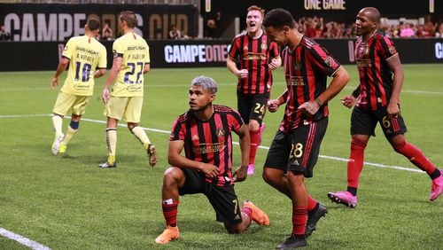 August 14, 2019 Atlanta: Atlanta United forward Josef Martinez strikes a pose for the fans after making what turned out to be the winning goal on a penalty kick for a 3-2 victory over Club America as teammates arrive to celebrate in the Campeones Cup on Wednesday, August 14, 2019, in Atlanta.   Curtis Compton/ccompton@ajc.com
