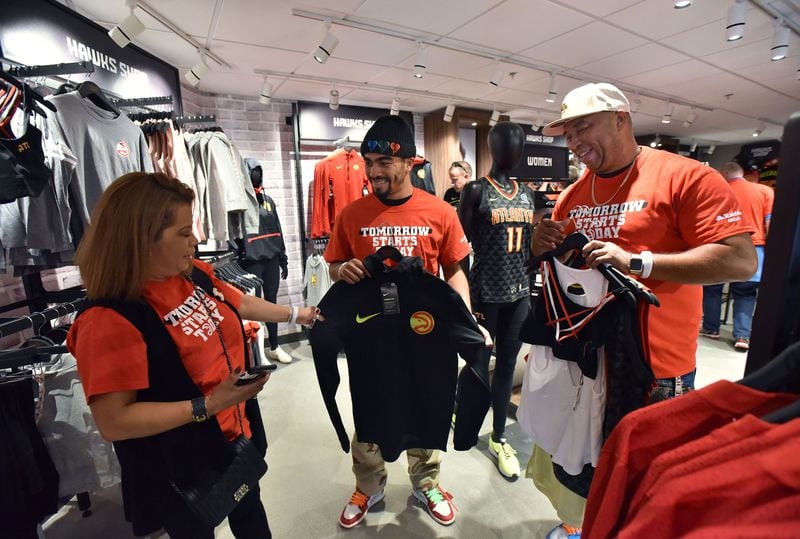 BJ Woods, his wife, Marleny, and their son Austin, who is 20, do some shopping before game. HYOSUB SHIN / HSHIN@AJC.COM